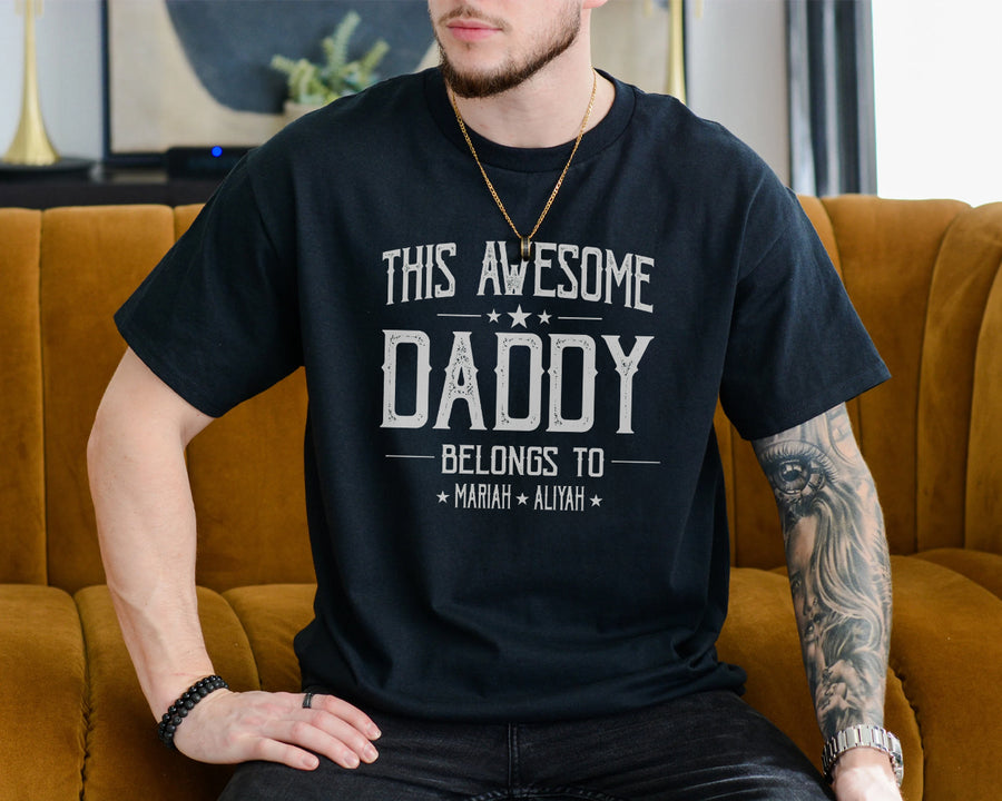 White unisex t-shirt with bold text reading This Awesome Daddy Belongs To with two children's names, dad fathers day gifts idea