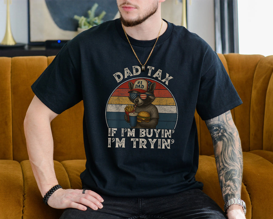 Dad tax if I'm buying I'm trying t-shirt featuring a cool raccoon in a #1 Dad cap holding a burger and fries with a retro American flag design