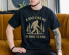Black t-shirt with a bigfoot sasquatch among pine trees and the text A Dad Like Me Is Hard to Find, funny bigfoot dad shirt
