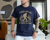 Navy t-shirt with a bigfoot sasquatch among pine trees and the text A Dad Like Me Is Hard to Find, funny bigfoot dad shirt