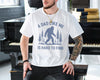 White t-shirt with a bigfoot sasquatch among pine trees and the text A Dad Like Me Is Hard to Find, funny bigfoot dad shirt