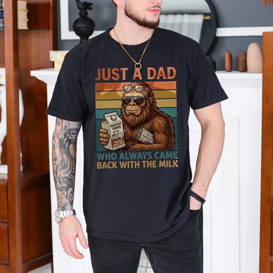 Black unisex funny dad bigfoot milk shirt featuring a cool Sasquatch in sunglasses holding a milk carton with retro sunset stripes