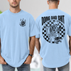 Light Blue funny dad shirt with a skeleton sitting on a toilet scrolling a phone, checkerboard background, Doing Dad Shit text