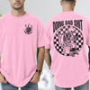 Light Pink funny dad shirt with a skeleton sitting on a toilet scrolling a phone, checkerboard background, Doing Dad Shit text