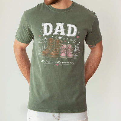 Black girl dad shirt featuring large work boots beside small pink girl boots with the words Dad My First Love My Forever Hero printed on the chest