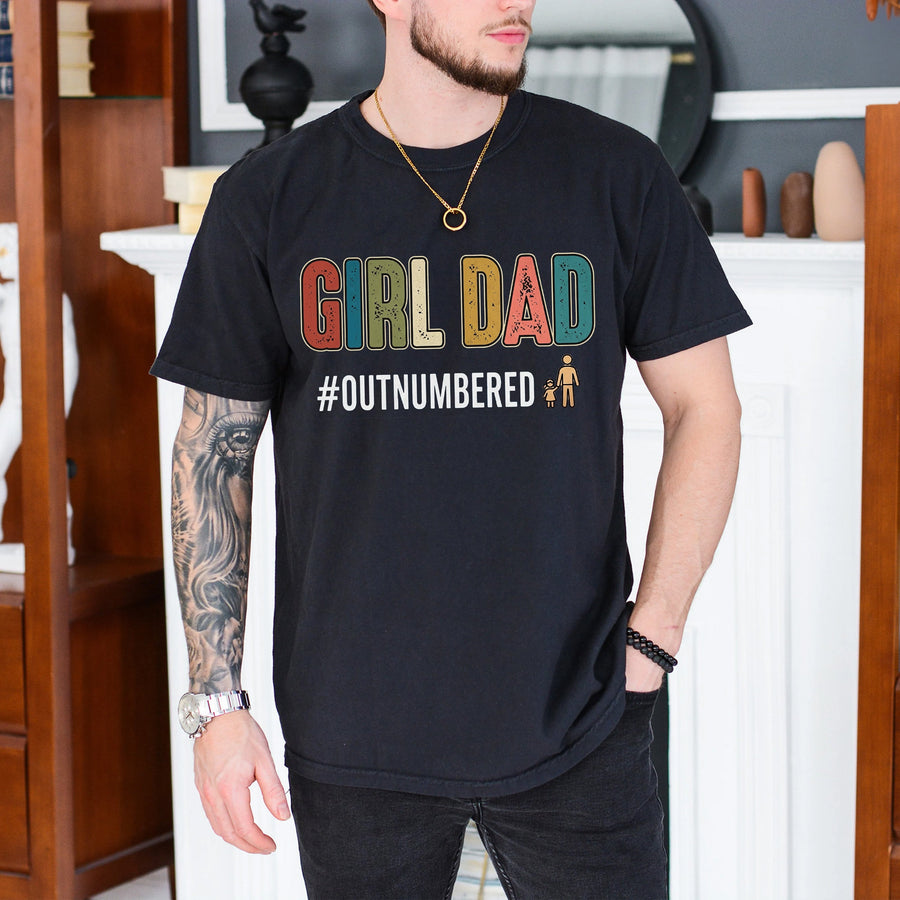 Black unisex girl dad shirt with colorful retro lettering reading Girl Dad and hashtag Outnumbered printed on the chest