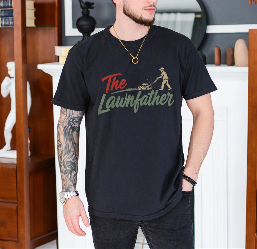 Black unisex lawnfather shirt with retro graphic of a man pushing a lawn mower and bold The Lawnfather text