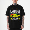 Black unisex t-shirt with leveled up to daddy 2027 gamer design featuring game controllers and a progress bar graphic