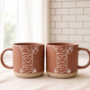 Personalized anniversary mug set with custom initials and date inside a carved heart on a tree illustration, cream and blue coarse ceramic