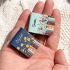 Personalized birth flower bookmark in vintage floral design showing stacked books and custom name printed on faux leather cover