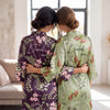 Personalized birth flower bridesmaid robe in light blue satin with orange florals, custom name Charlotte and monogram on back