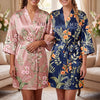 Personalized birth flower bridesmaid robe in light blue satin with orange florals, custom name Charlotte and monogram on back