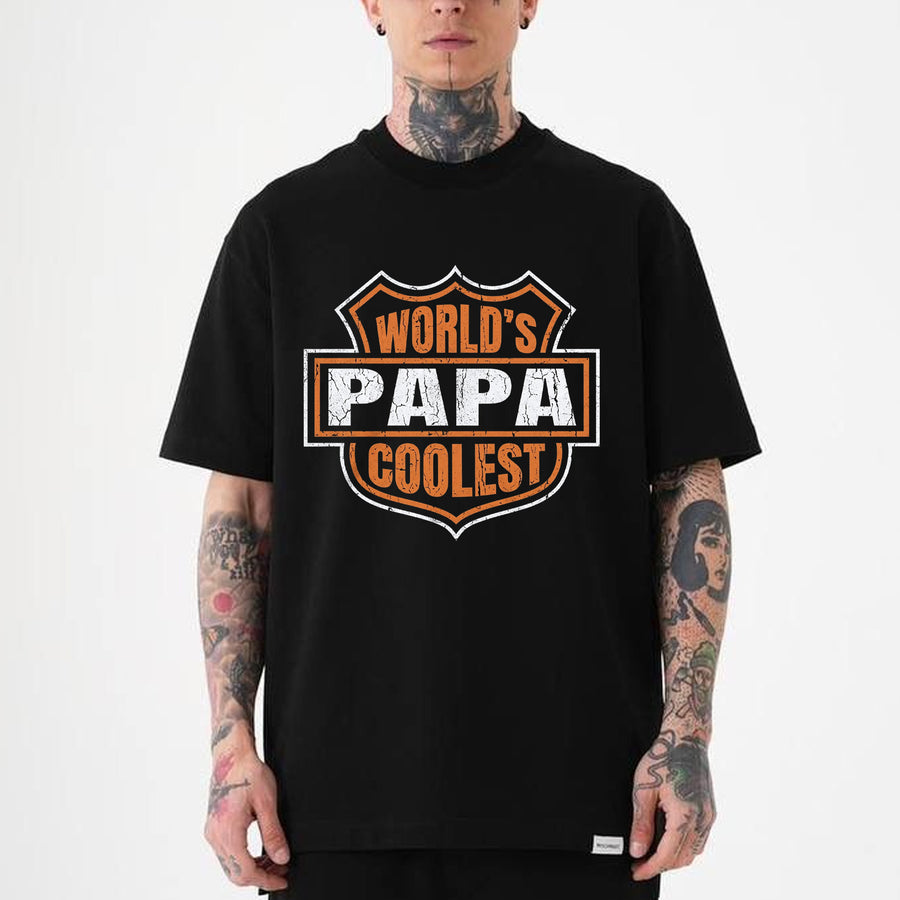 black t-shirt with a distressed badge graphic reading World's Coolest Papa in white and orange bold lettering